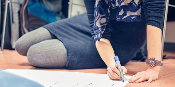 Frau mit einem Stift auf dem Boden