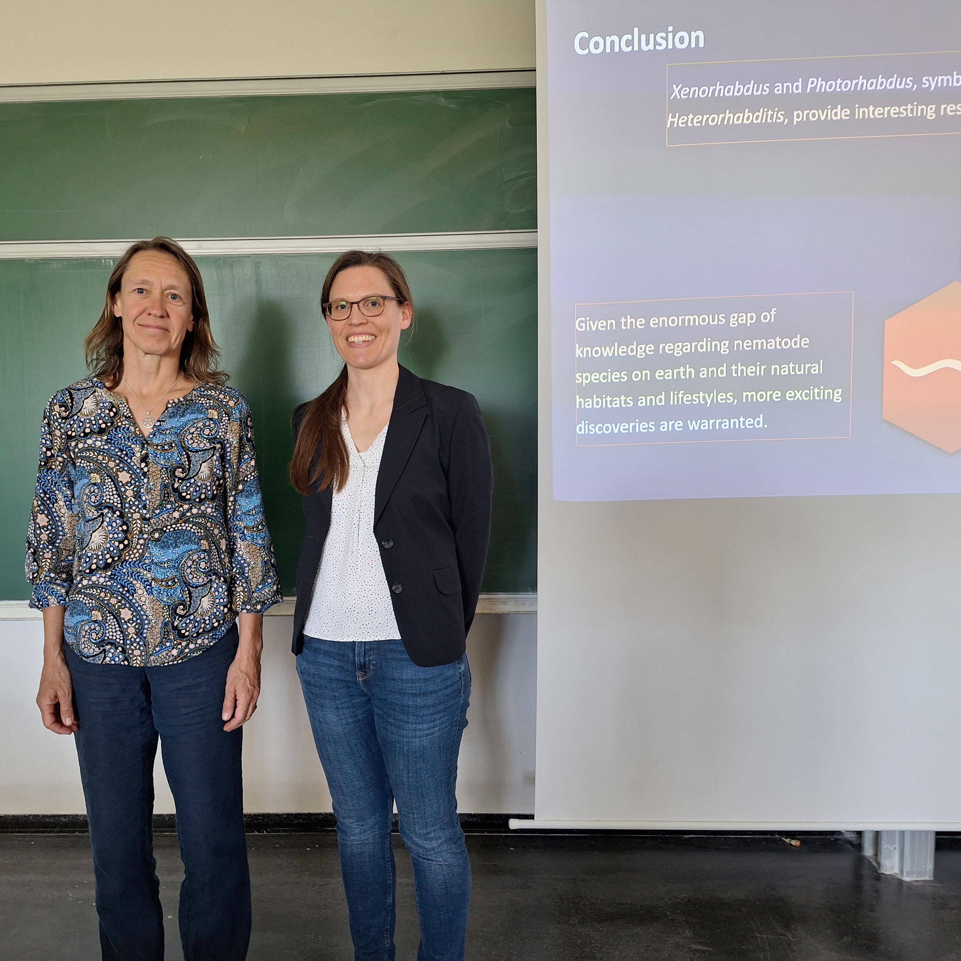 Dekanin Dagmar Klostermeier und Verena Spieler vor der Tafel nach dem wissenschaftlichen Vortrag.
