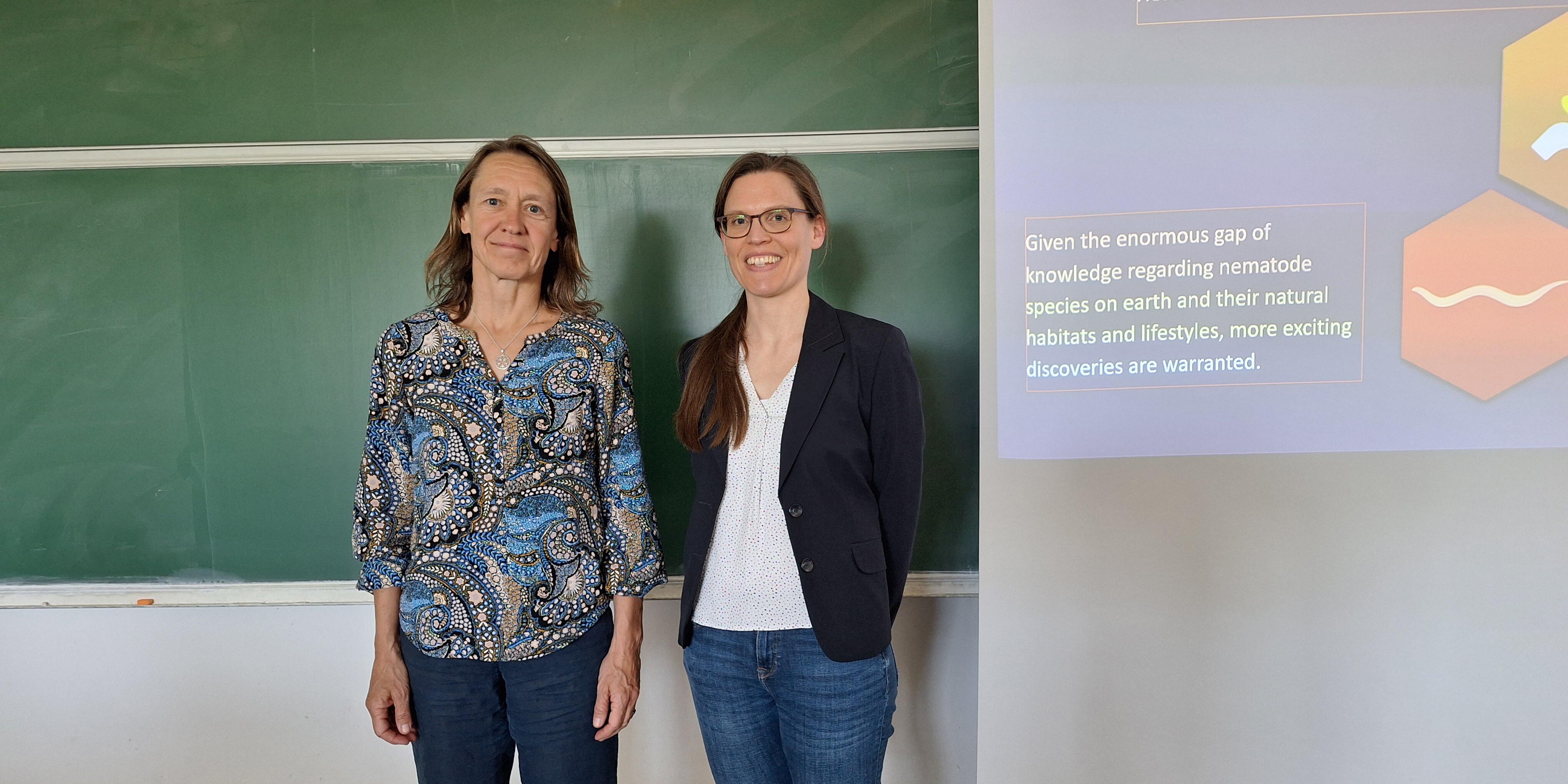 Dekanin Dagmar Klostermeier und Verena Spieler vor der Tafel nach dem wissenschaftlichen Vortrag.