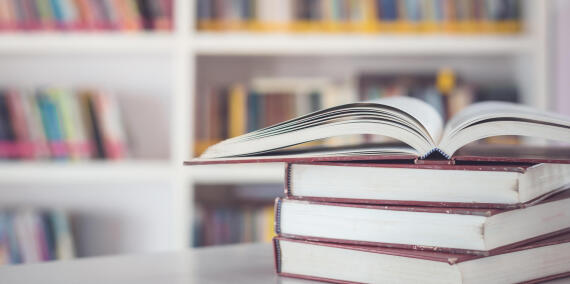 Book stack on the table in the library room and blurred space of